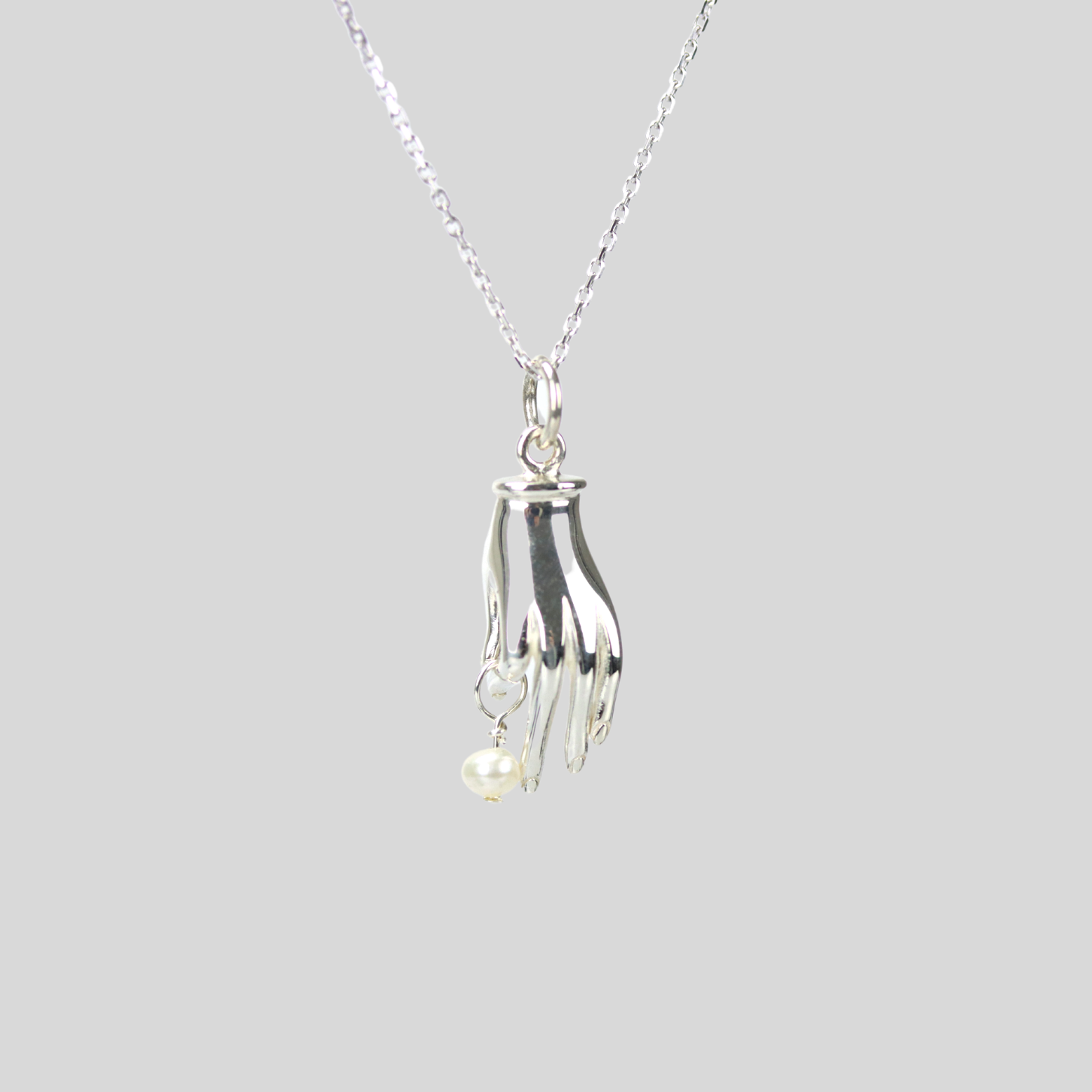 Holding hand necklace with dangling pearl